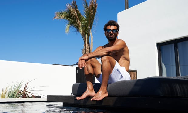Salah sits by pool in white swimming trunks