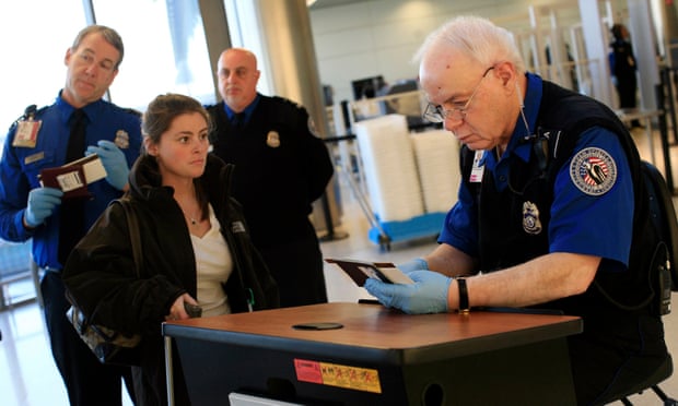 A TSA officer checks the identification of a passenger at an airport security checkpoint