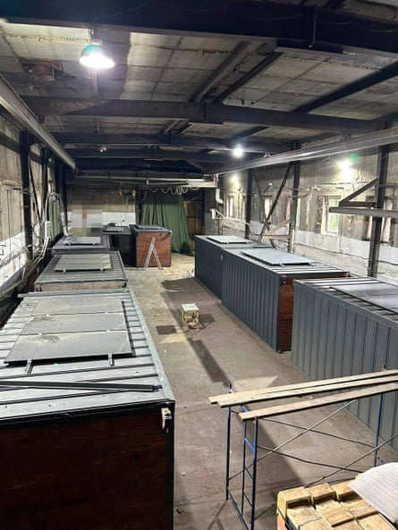 Seven grey quadrilateral shed roofs sitting in a warehouse