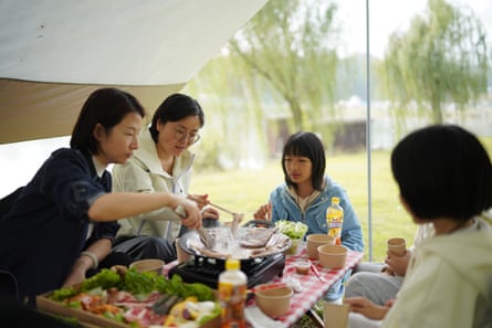 The two families eating together outdoors