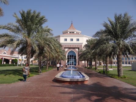 Grand Arabic-style building with fountain and palm trees