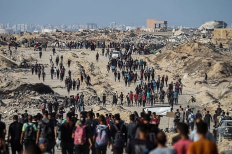 Palestinians gather along the coastal road in the Al-Sudaniyya area in northern Gaza as they wait to receive humanitarian aid expected to enter through the Zikim crossing.