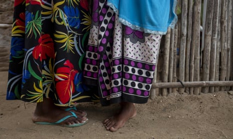 Two women, seen from the waist down in colourful dresses, stand in Paquitequete, a neighbourhood of Pemba City