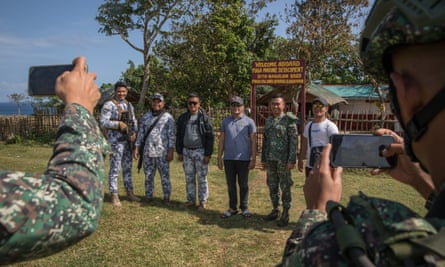 Philippine Navy marines and coast guard personnel take souvenir photos during a visit to Fuga Island