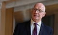 John Swinney in suit and purple tie and glasses looking animated