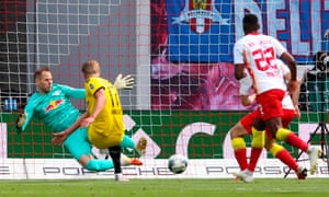 Dortmund’s Erling Braut Haaland shoots past Leipzig’s goalkeeper Peter Gulacsi to score the opening goal.