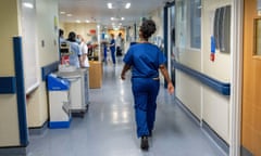A nurse walks down a hospital corridor.