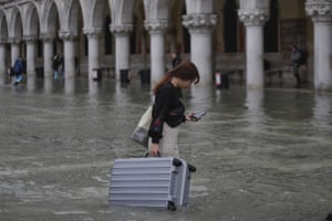 A tourist carries her luggage in a Piazza San Marco