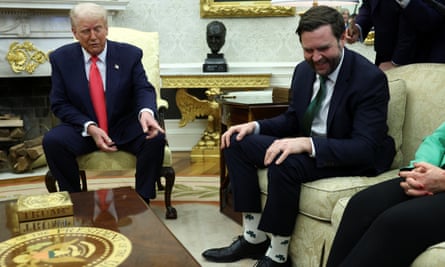 Donald Trump smiles as he points to the shamrock-patterned socks worn by the vice-president