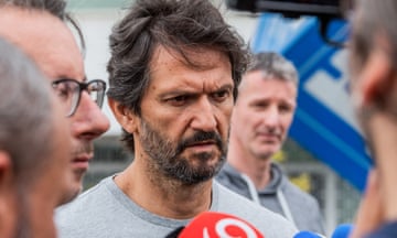 Robert Kaliňák, bearded and wearing a grey T-shirt, speaking  to reporters