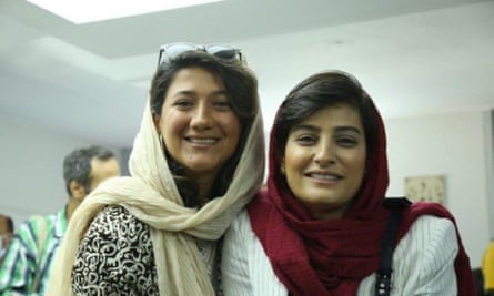 Two young women in headscarves smiling at the camera