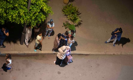 People stand in a street after Rabat was shaken by the quake