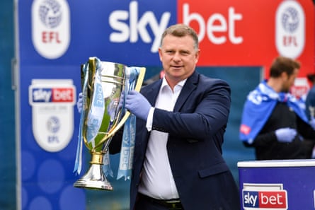 Le manager de Coventry, Mark Robins, soulève le trophée de la Ligue 1 sur le terrain d'entraînement du club à Ryton en juin 2020.