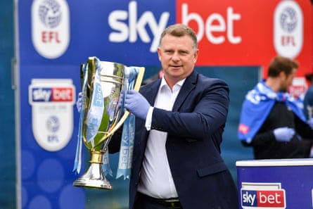 El gerente de Coventry, Mark Robins, levanta el trofeo de la Liga Uno en el campo de entrenamiento Ryton del club en junio de 2020.