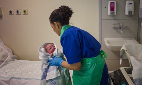 A newborn baby and maternity nurse at an NHS England hospital.
