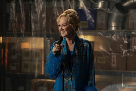 woman in blue outfit smiles while holding up microphone