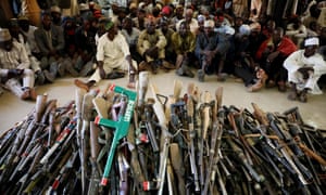 Members of the Yansakai vigilante group sit inside an auditorium in Gusau after surrendering more than 500 guns to the Zamfara state governor in December.