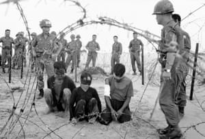 Korean troops guard three Vietnamese captives found near a village south of Tuy Hoa in November 1966