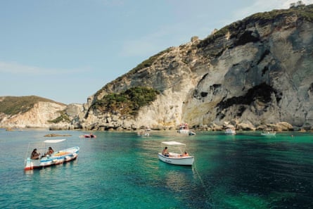 Several boats anchored off rocky cliffs