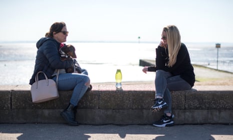 Two friends meet by Chalkwell beach, Southend-on-Sea, March 2021. 