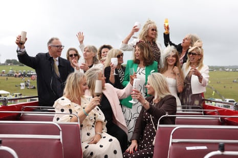 Racegoers enjoy drinks on an open top bus during Derby day at Epsom.
