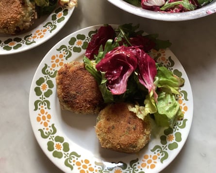 A plate with fish cakes and a leafy salad