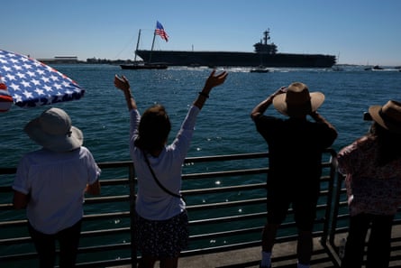 People on deck cheer returning soldiers