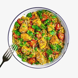 طبق أرز من ريفرد مع أوراق خضراء وطماطم حمراء من الأعلى.