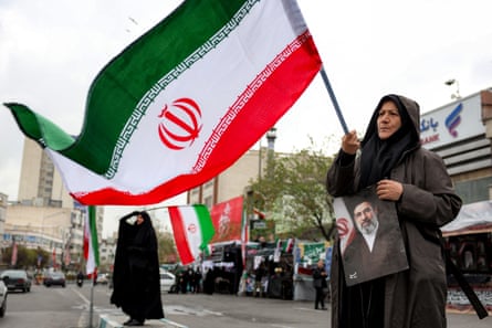 A woman holds a picture of Iran’s new Supreme Leader Mojtaba Khamene