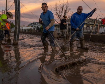 Residents sweep mud.