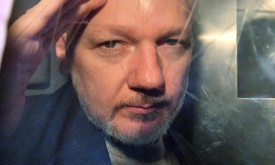 In this file photo taken on 1 May, 2019 WikiLeaks founder Julian Assange gestures from the window of a prison van.
