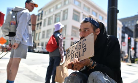 Homeless man begs along a sidewalk in downtown San Francisco