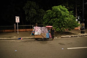 A homeless man stands next to his pushcart as he looks for a place to park for the night in Manila, Philippines