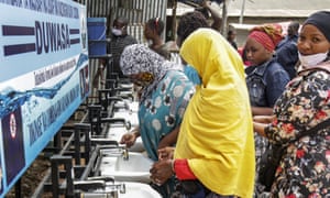 People use a hand-washing station installed for members of the public entering a market in Dodoma, Tanzania.