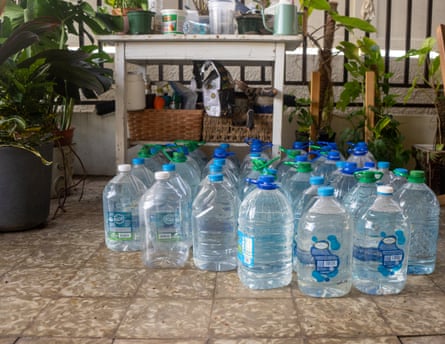 Dozens of water bottles sit on a floor. Dozens of water bottles sit on a floor.