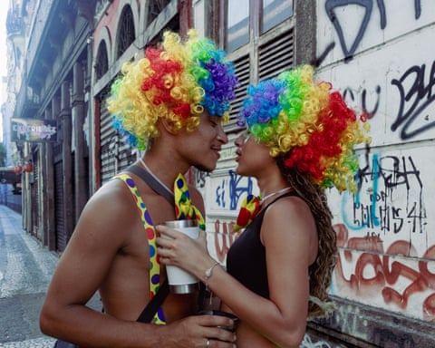 A couple dressed as clowns about to kiss