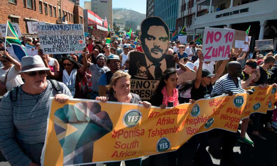 People march through Cape Town in 2017 calling for Jacob Zuma to step down, with a poster showing Atul Gupta.
