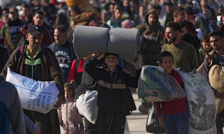 Palestinians carrying bags and sacks of flour