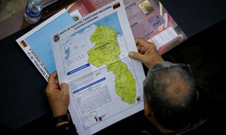 Overhead shot of balding man holding large white map with neon-green area in the middle.