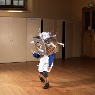 A child wears a silver-foil covered box on its head