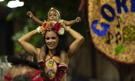 A reveller of a street party known as ‘blocos’ holds a baby as she dances during a protest against restrictions by city officials in Rio de Janeiro, Brazil, on 13 April. 
