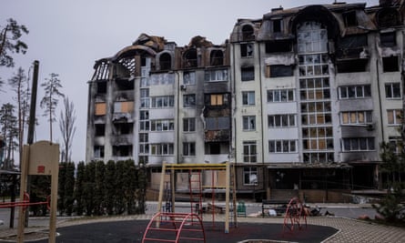 Destroyed blocks of flats stand behind a playground in Irpin