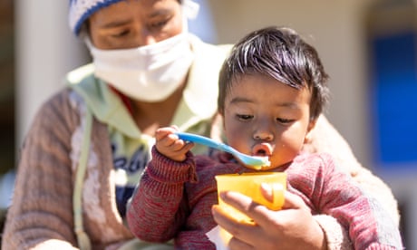A child eats fruit delivered by Unicef and fortified with vitamins with his mother in a village in Guatemala last year.