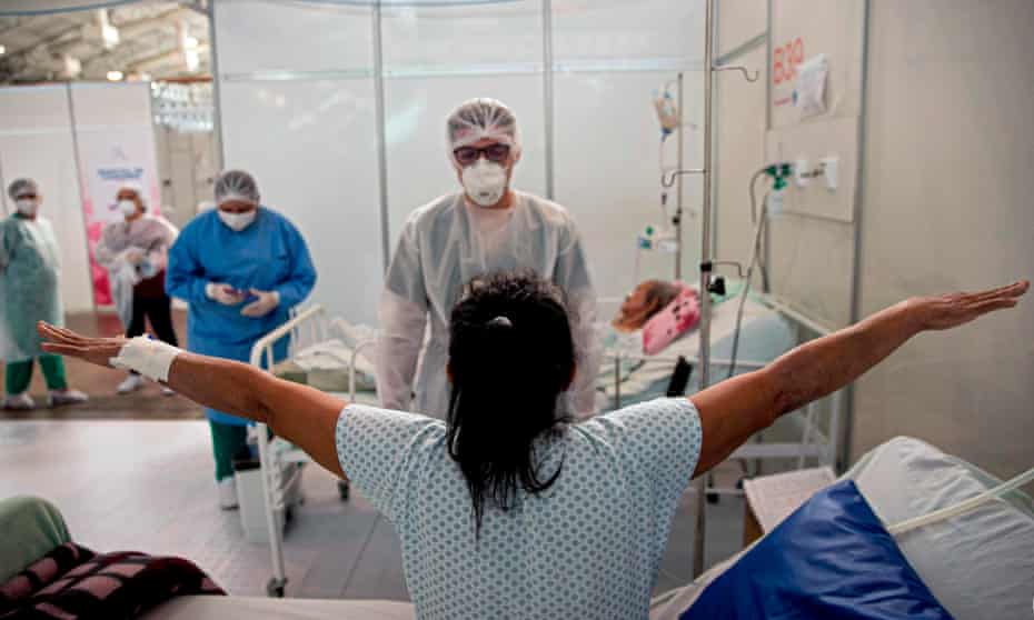 A doctor checks a COVID-19 patient at a field hospital in Belem, Para state, Brazil. For some, a second infection is less severe than the first.