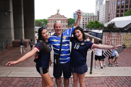 Two women and a man in Scotland shirts pose for the camera