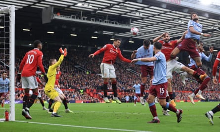 Casemiro of Manchester United clears the ball with a header as Tyrone Mings of Aston Villa leaps