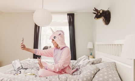 Playful woman in unicorn costume in bedroom