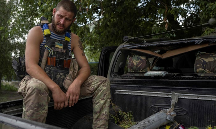 A Ukrainian soldier with part of rocket fired by Russian forces in Bakhmut