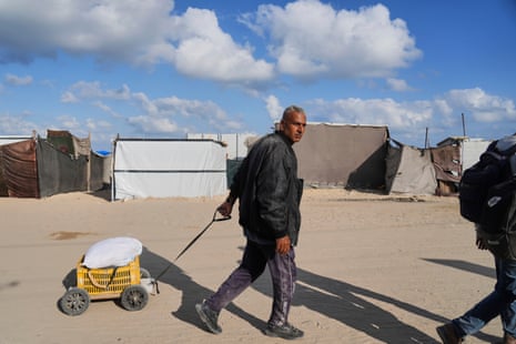 Displaced Palestinians have to walk significant distances to and from the limited number of distribution points.