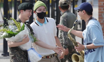 K-pop band BTS's member Jin, left, is greeted by other members j-hope, center, and RM, right, after being discharged from a mandatory military service outside of an army base in Yeoncheon, South Korea